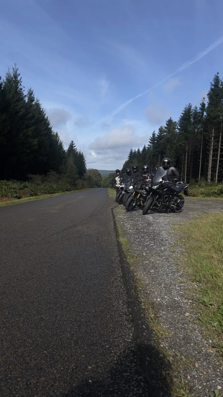 Motoren in een rij langs een rechte weg door het bos
